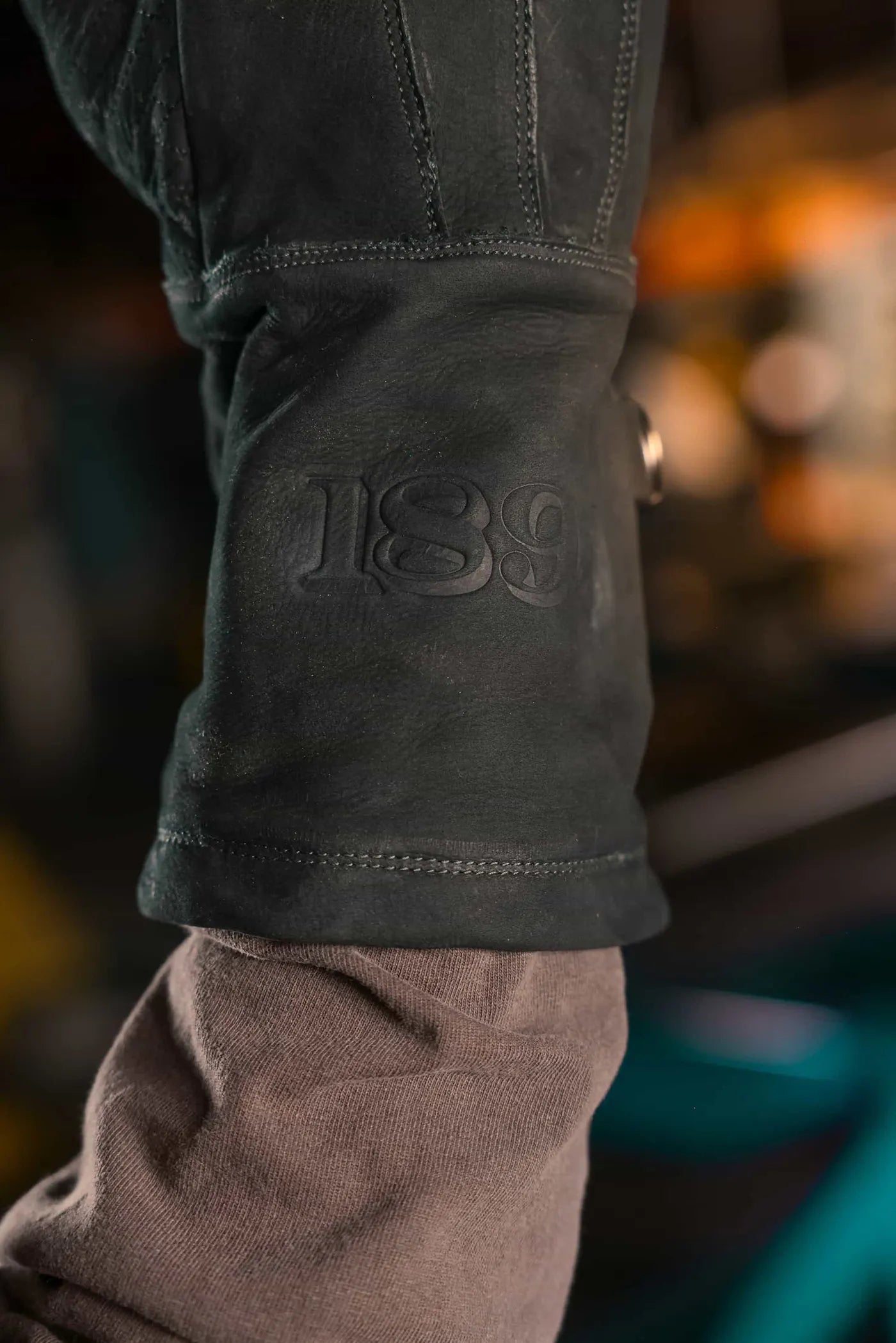 Close up of black-thread leather work glove with embossed 1898 brand logo and button closure on the wrist, highlighting craftsmanship and secure fit Rated 4.70 – Black