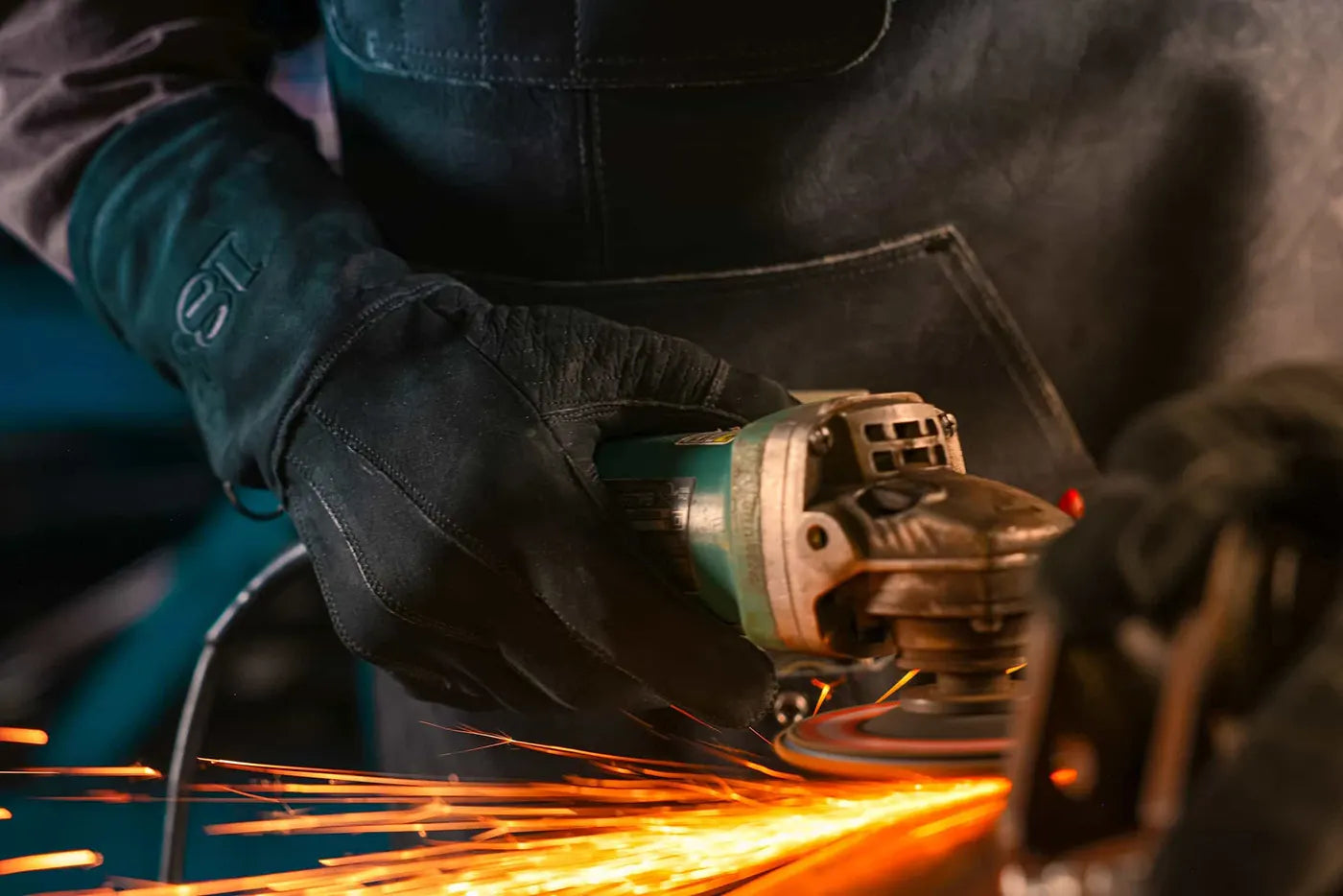 Black-thread leather work gloves in use during intense metal grinding, with sparks flying to highlight durability, grip, and heat resistance Rated 4.70 – Black