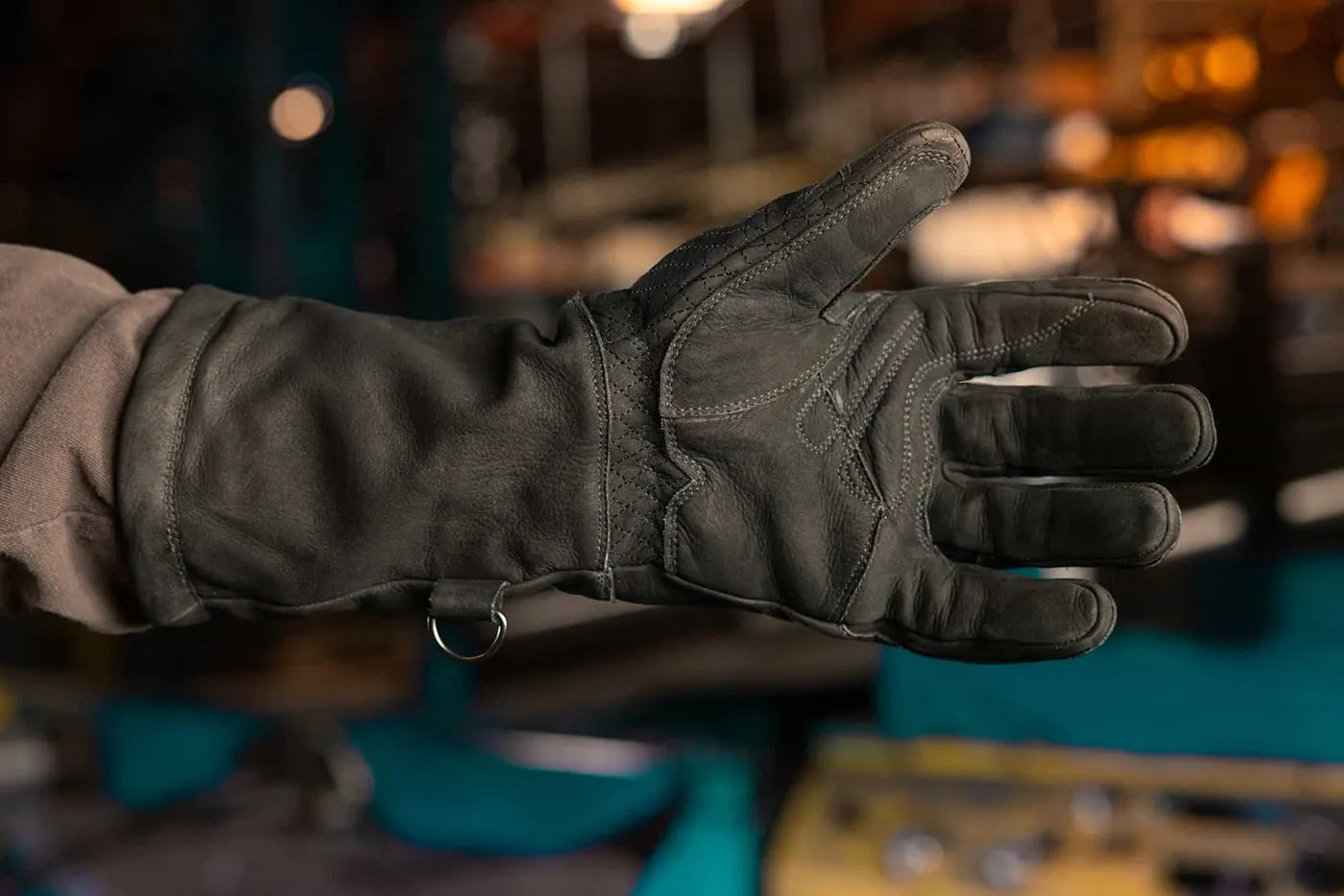 Close up of black-thread leather work glove showing reinforced palm stitching and metal ring near the wrist, highlighting grip, durability, and functional design Rated 4.70 – Black