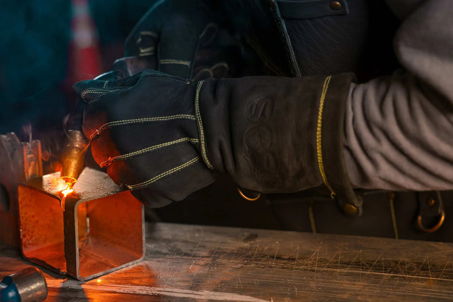Close up of gold-thread leather welding gloves in use during active welding, with bright sparks and molten metal highlighting heat resistance and precision Rated 4.70 – Gold