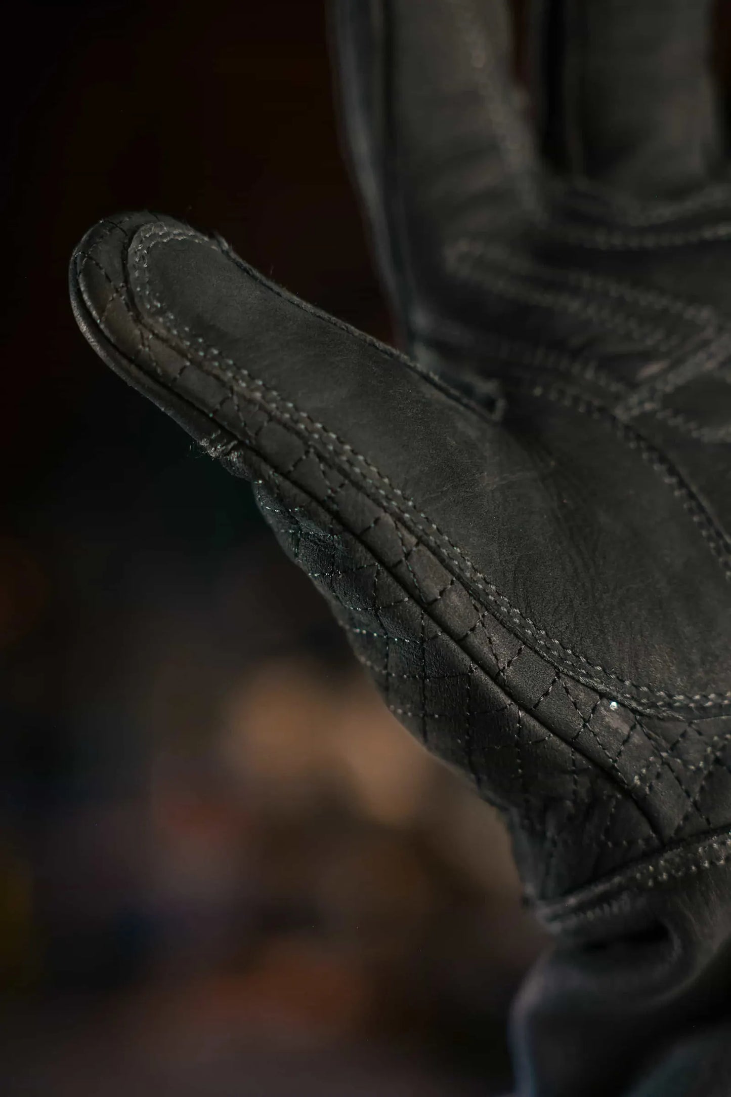 Extreme close-up of black leather work glove with black stitching, showing fine grain texture and seam construction, highlighting durability and craftsmanship Rated 4.70 – Black
