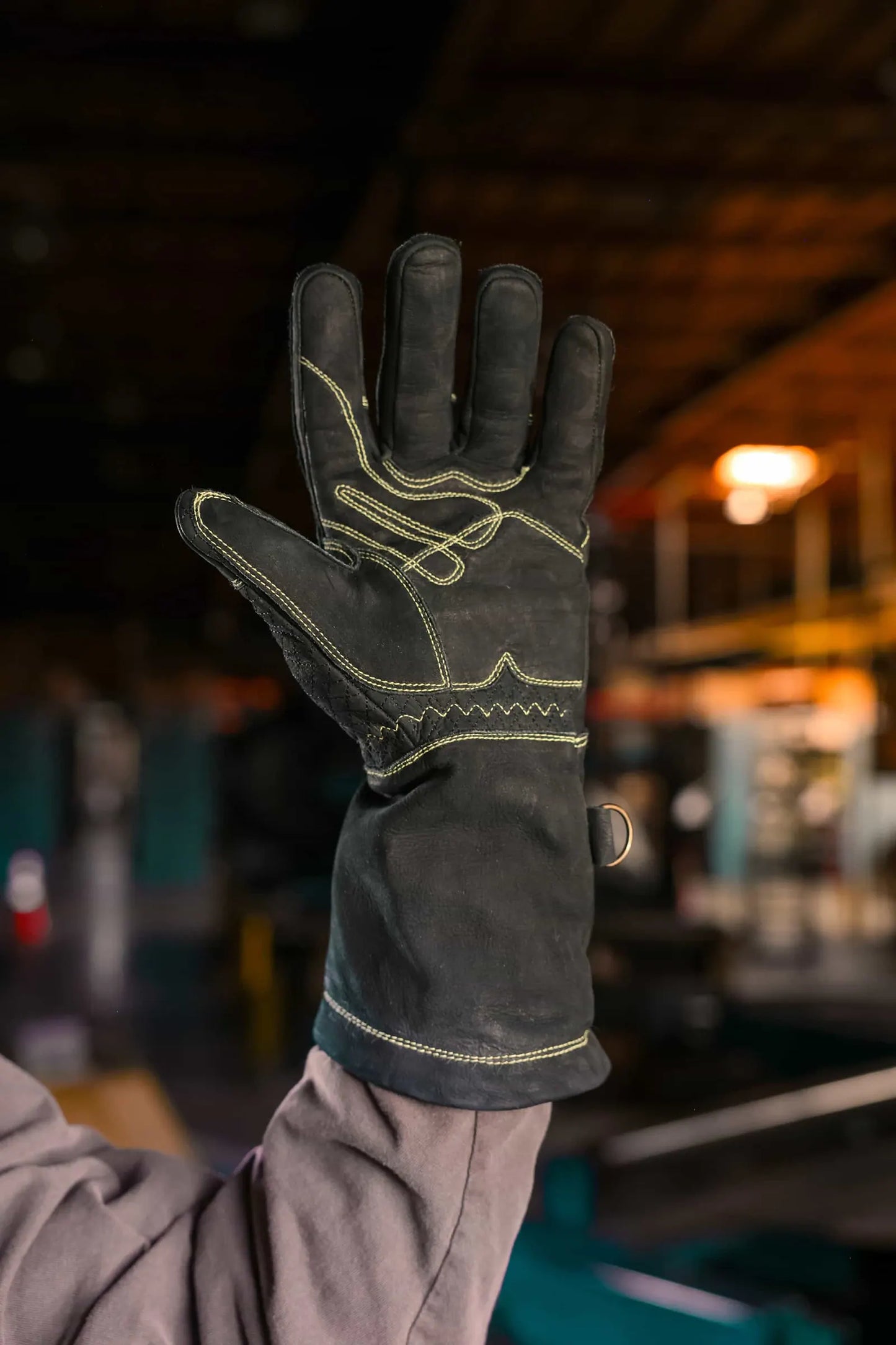 Palm-side view of leather work glove with gold stitching, showing reinforced seams and textured leather surface for grip and durability Rated 4.70 – Gold