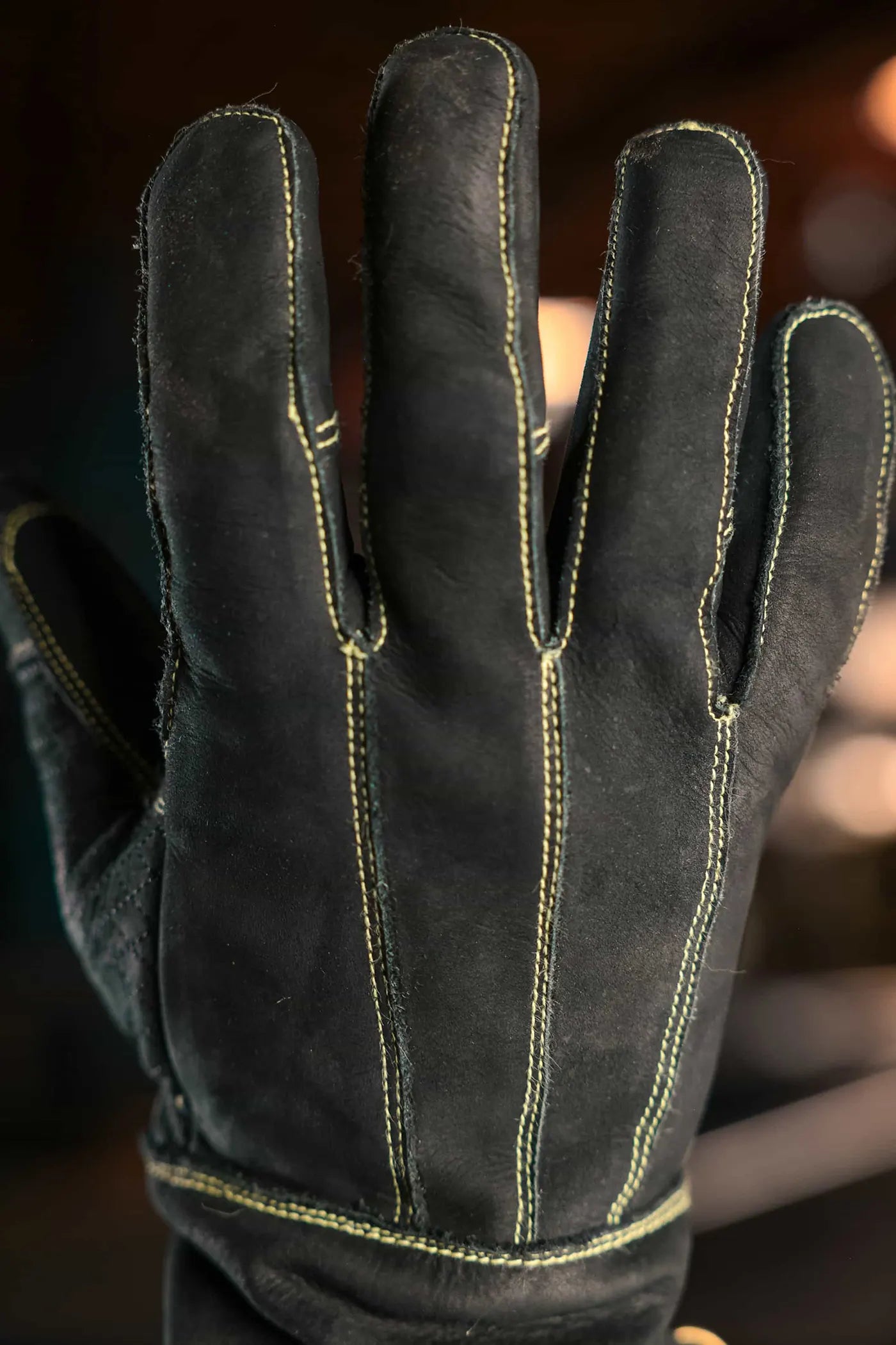 Close up of leather work glove with gold stitching, worn on a hand with visible vertical and wrist-area seams, highlighting fit, craftsmanship, and durability Rated 4.70 – Gold