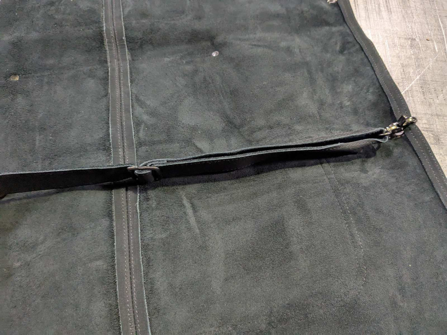 Back of black 1898 Leather welding apron with adjustable waist strap and trigger-snap buckle