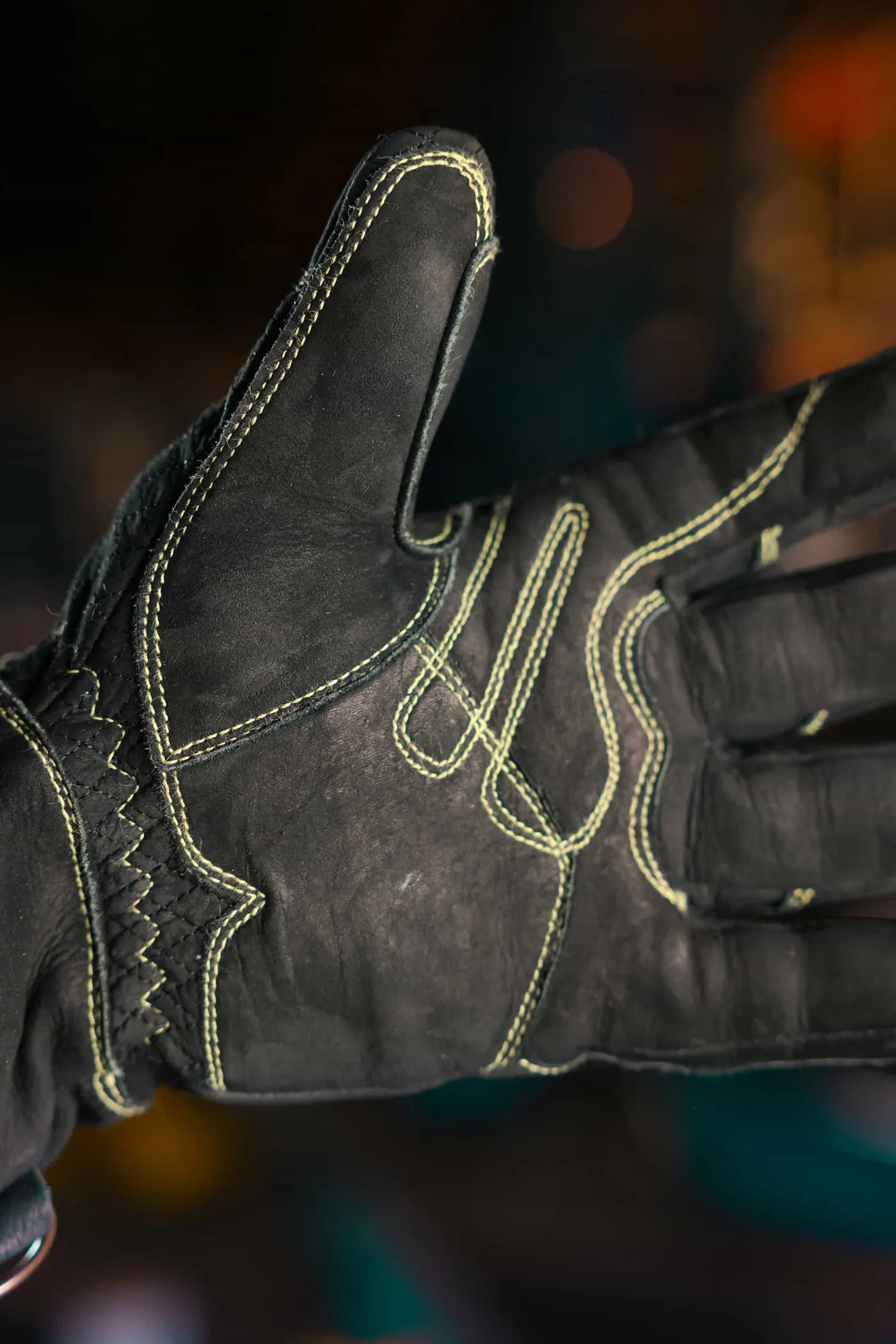 Palm side close up of yellow-thread leather work glove showing reinforced stitching and textured leather surface, highlighting grip, durability, and craftsmanship – Rated 4.70 – Gold