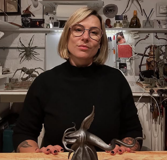 Metal artist Leah Aripotch with a steel squid sculpture and insect sculptures in her studio