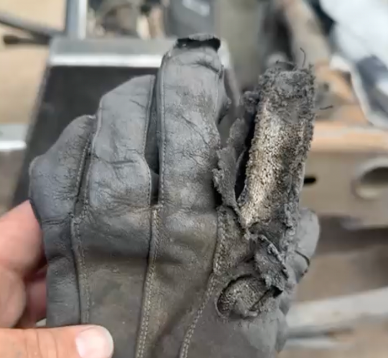 Worn 1898 Leather welding glove after months of use, showing frayed Kevlar stitching at the fingers