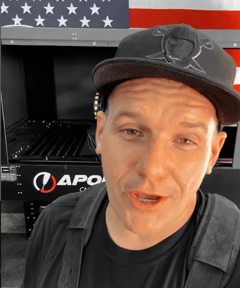 Metal artist Todd Isaac in front of an Apollo CNC plasma table and American flag