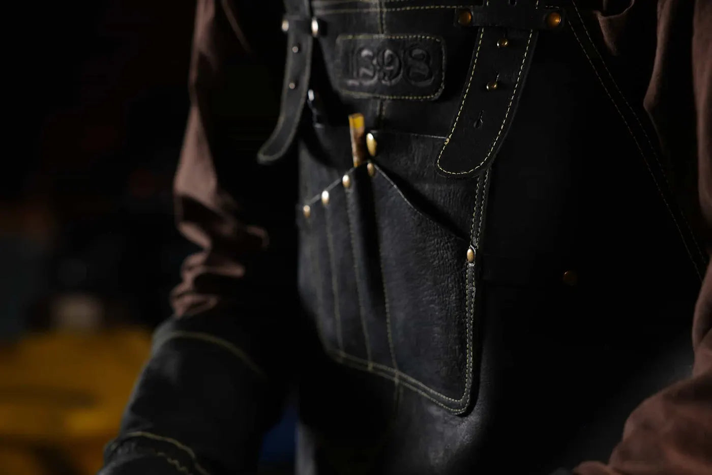 Close-up of 1898 Leather welding apron with gold thread on neck strap and detailed chest pockets premium quality, 4.85-star rated apron designed for durability and convenience - Gold