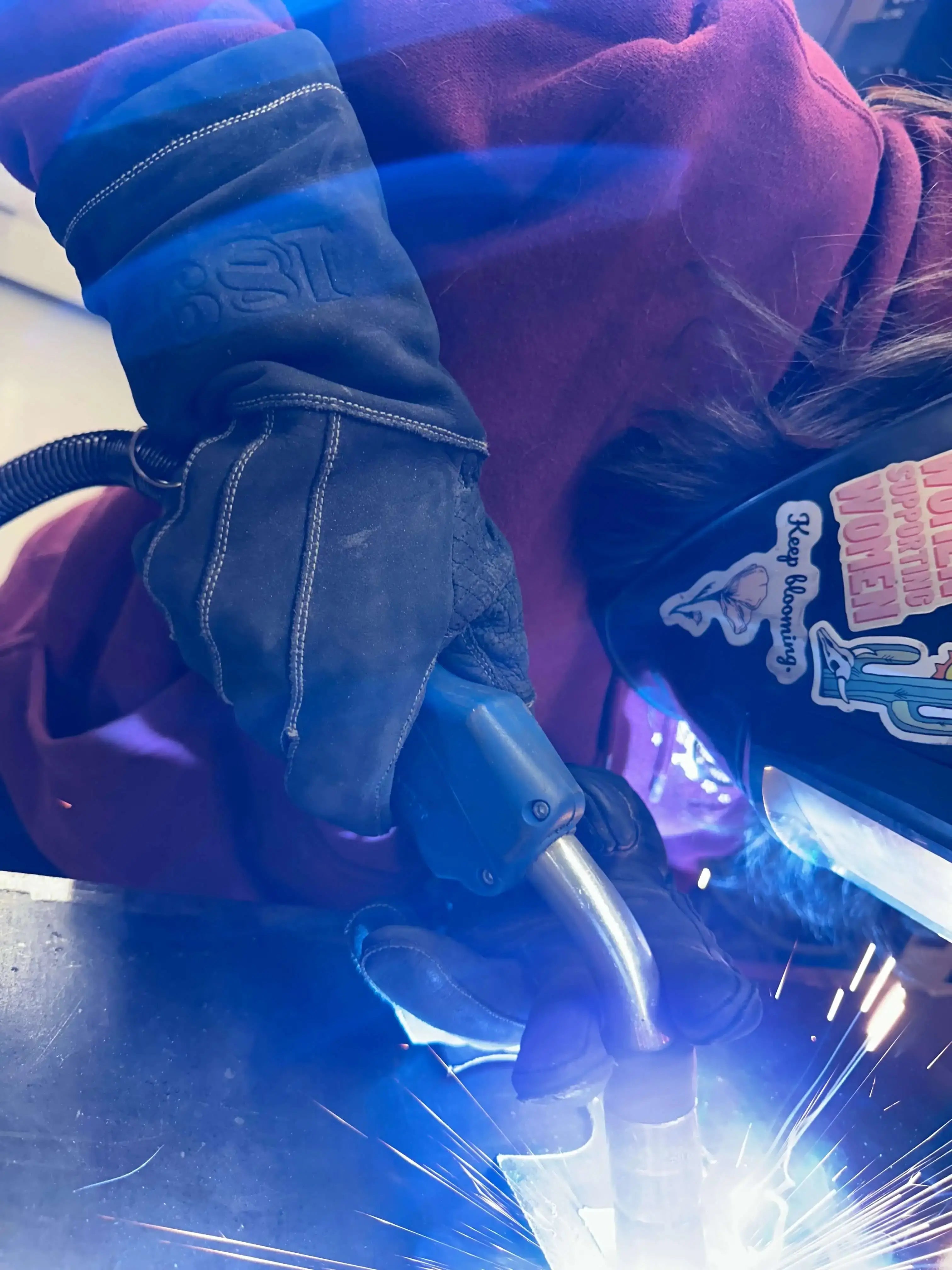 Side view of Utah State student welding while wearing 1898 Leather welding gloves — trusted 4.7-star safety gear for students and professionals