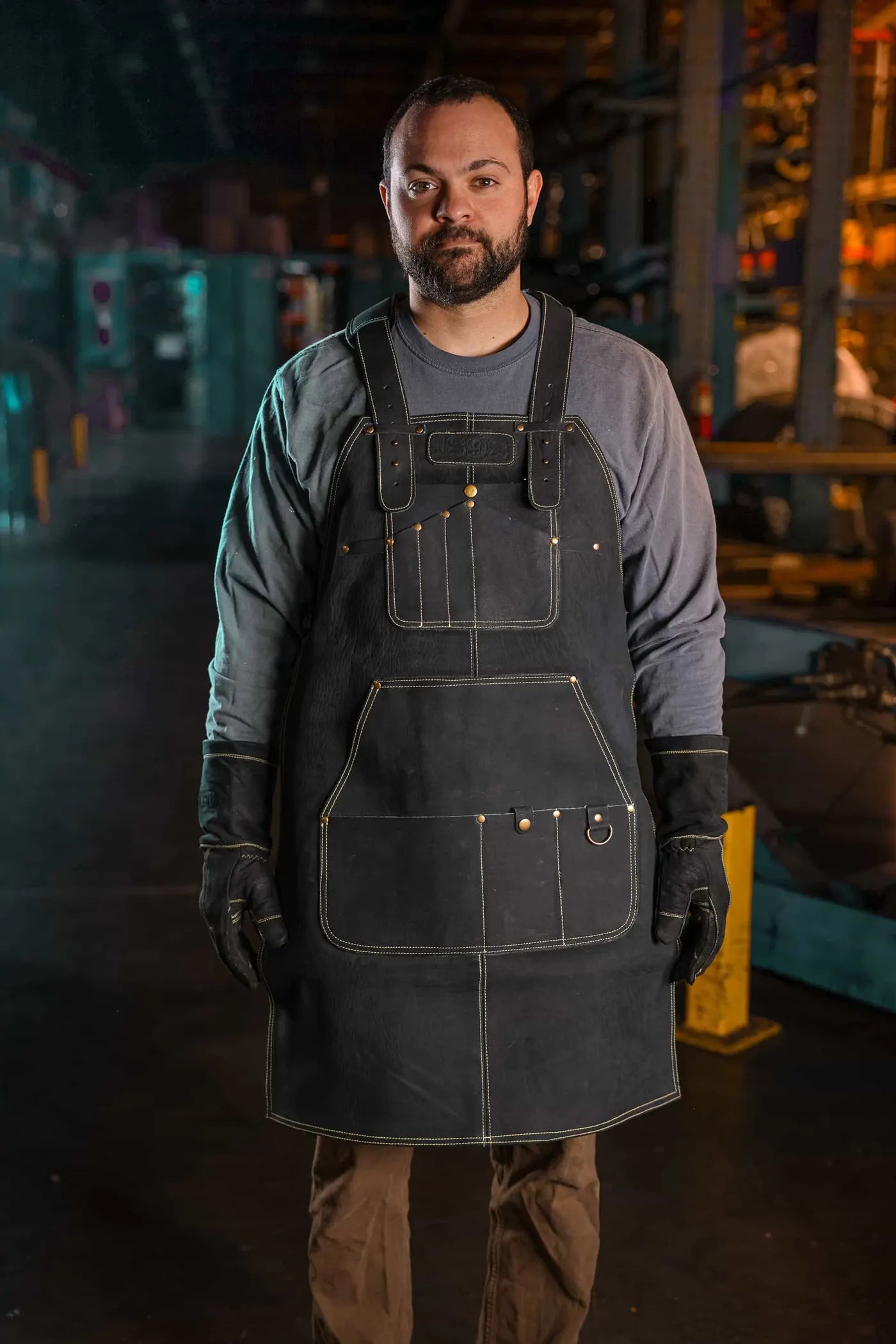 Big and tall model wearing heavy duty leather welding apron and gloves, front view, showcasing durable protective gear with 4.85 apron and 4.70 gloves ratings, Gold