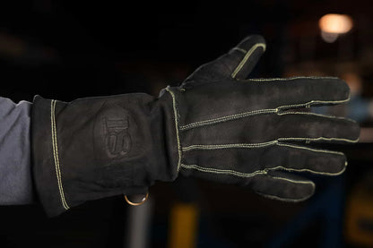 Close up of leather work glove with gold stitching and embossed 1898 logo on the wrist, worn in an indoor setting, highlighting craftsmanship, branding, and premium construction Rated 4.70 – Gold